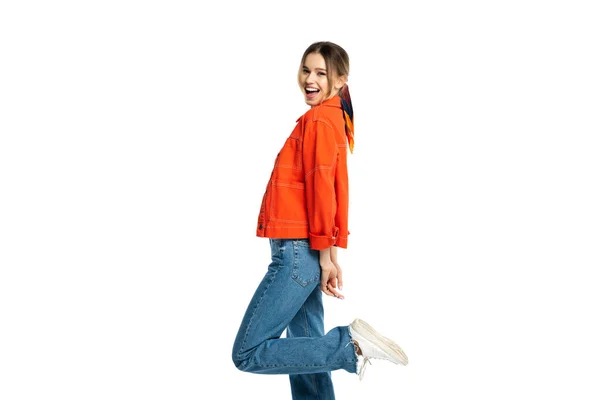 Aufgeregte junge Frau in Jeans, bauchfreiem Oberteil und orangefarbenem Hemd posiert isoliert auf weißem Hintergrund — Stockfoto