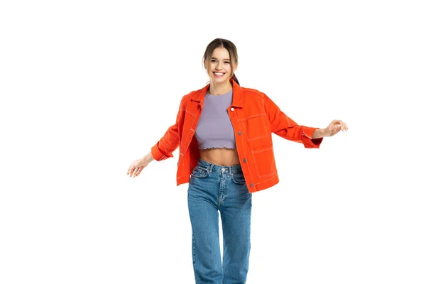 Allegra giovane donna in jeans, crop top e camicia arancione posa isolata su bianco — Foto stock
