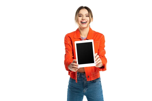 Alegre joven en camisa naranja y jeans sosteniendo tableta digital con pantalla en blanco aislado en blanco - foto de stock