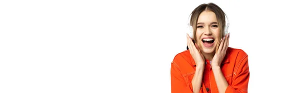 Mulher alegre em camisa laranja ouvindo música em fones de ouvido sem fio isolados em branco, banner — Fotografia de Stock