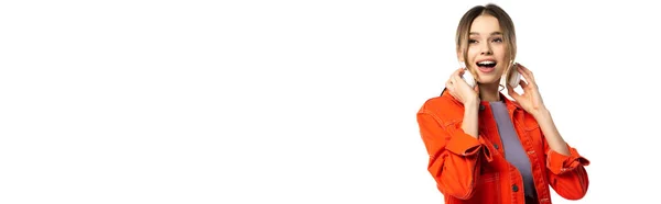 Fröhliche Frau in orangefarbenem Hemd mit kabellosen Kopfhörern auf weißem Hintergrund, Banner — Stockfoto