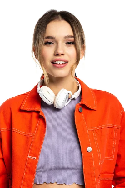 Mulher alegre em camisa laranja e fones de ouvido sem fio isolados em branco — Fotografia de Stock