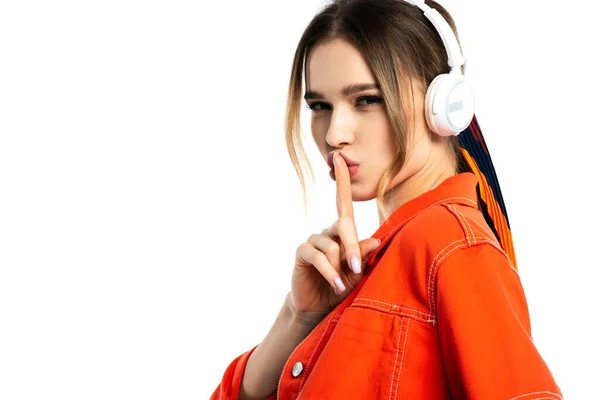 Жінка в помаранчевій сорочці слухає музику в бездротових навушниках і показує знак хіта ізольовано на білому — стокове фото