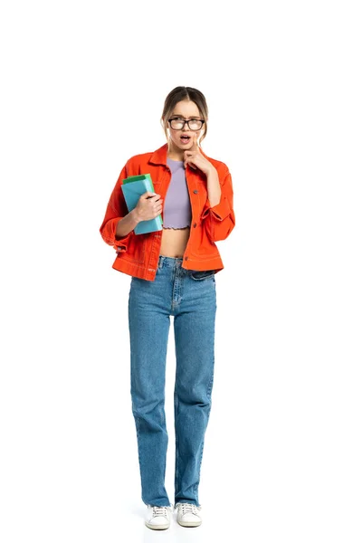 Full length of surprised young student in glasses holding books isolated on white — Stock Photo