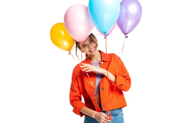 Glückliche junge Frau in orangefarbenem Hemd mit bunten Luftballons auf weißem Grund — Stockfoto