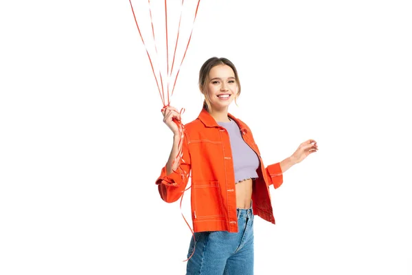 Happy young woman in orange shirt holding strips from balloons isolated on white — Stock Photo