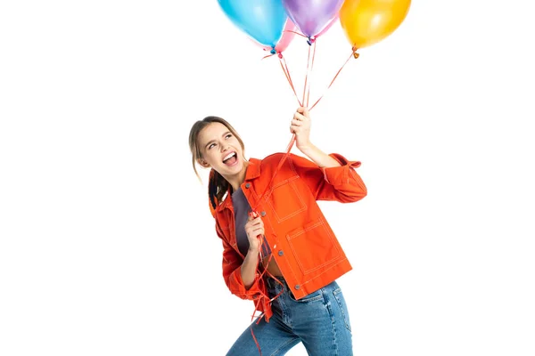 Excitée jeune femme en chemise orange tenant des ballons colorés isolés sur blanc — Photo de stock