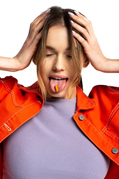 Woman sticking out tongue with capsule isolated on white — Stock Photo