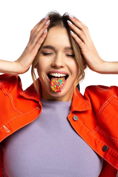 Young woman with closed eyes sticking out tongue with tasty sprinkles isolated on white — Stock Photo