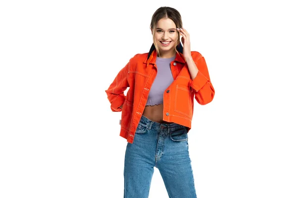 Joyeux jeune femme en jeans bleu, crop top et chemise orange posant isolé sur blanc — Photo de stock