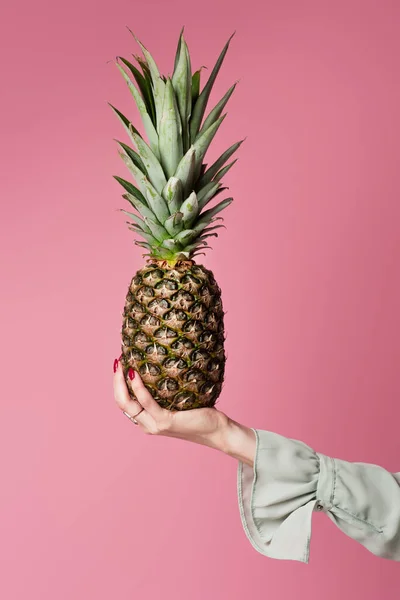Cropped view of woman holding pineapple isolated on pink — Stock Photo