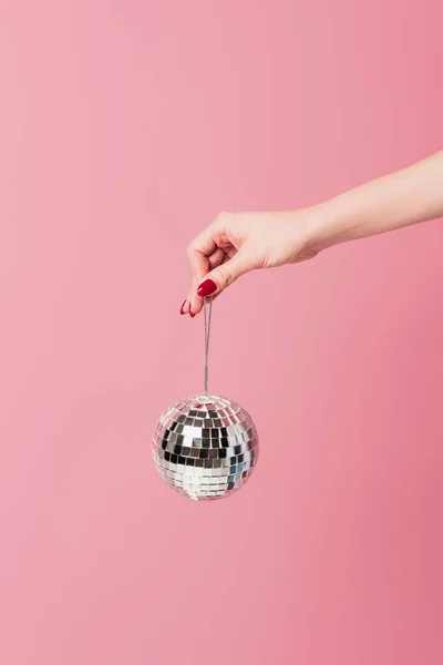 Vista cortada de mulher segurando bola de discoteca isolada em rosa — Fotografia de Stock