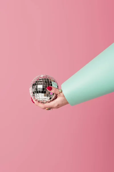 Vista cortada de bola de discoteca na mão de mulher isolada em rosa — Fotografia de Stock