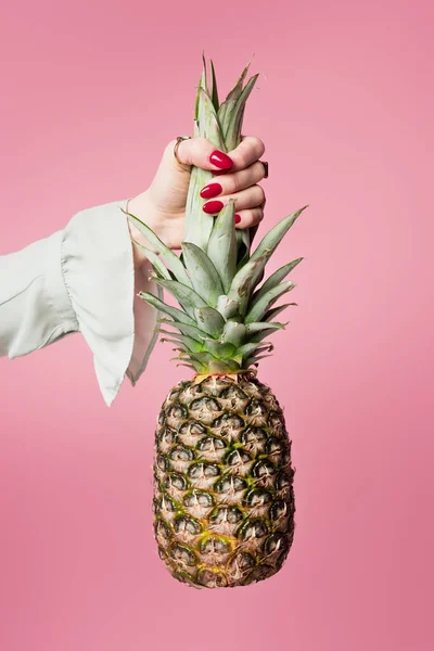 Vue recadrée de la femme avec manucure rouge tenant l'ananas isolé sur rose — Photo de stock