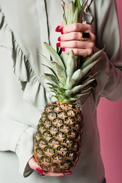 Cropped view of woman holding fresh pineapple isolated on pink — Stock Photo
