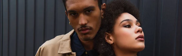 African american man looking at camera while posing with curly woman outside, banner — Stock Photo