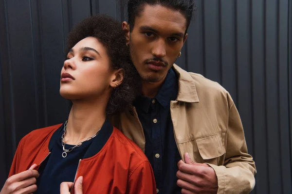 African american man looking at camera while posing with curly woman outside — Stock Photo