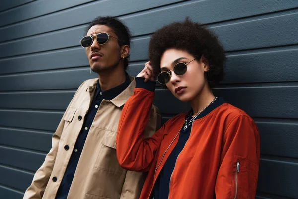 Young african american man posing with stylish woman in sunglasses outside — Stock Photo