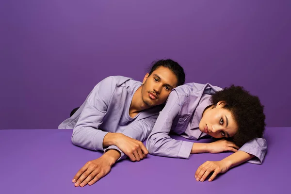 Young african american man leaning on woman isolated on purple — Stock Photo