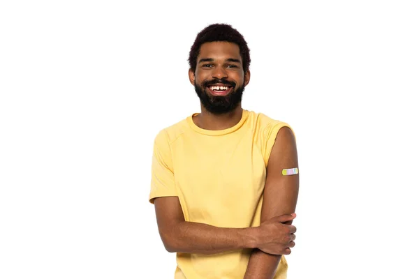 Uomo afroamericano con intonaco adesivo su braccio sorridente isolato su bianco — Foto stock