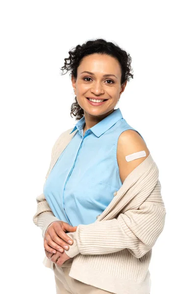 Mujer afroamericana sonriente con yeso adhesivo en brazo aislado en blanco - foto de stock