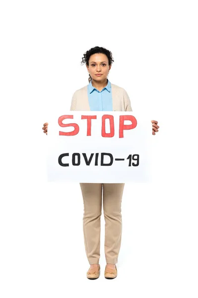 Mujer afroamericana sosteniendo pancarta con letras stop covid-2019 sobre fondo blanco - foto de stock