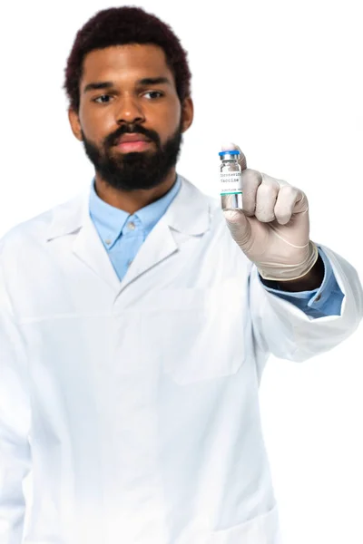 Jar with vaccine in hand of african american doctor on blurred background isolated on white — Stock Photo