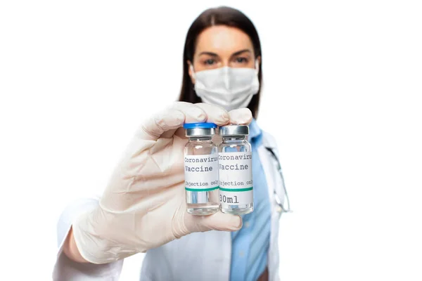 Jars with vaccine in hand of doctor in medical mask on blurred background isolated on white — Stock Photo