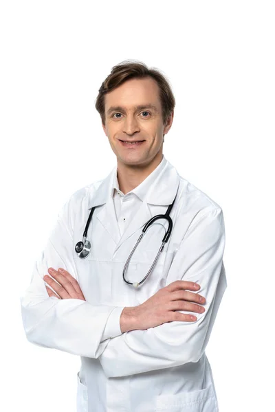 Médecin joyeux debout avec les bras croisés isolés sur blanc — Photo de stock