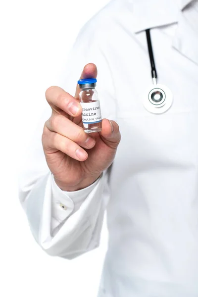 Vista recortada del frasco con la vacuna contra el coronavirus en la mano del médico desenfocado aislado en blanco — Stock Photo