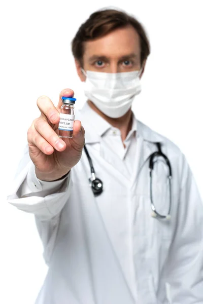 Vacuna contra el Coronavirus en la mano del médico borroso en máscara protectora aislada en blanco - foto de stock