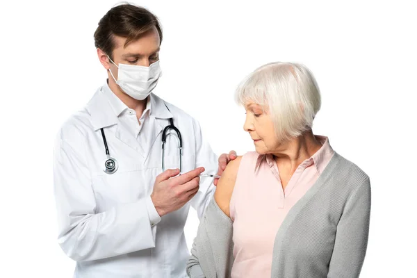 Medico in maschera medica che fa la vaccinazione di brevetto senior isolato su bianco — Foto stock
