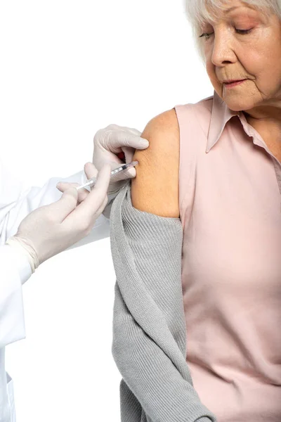 Femme âgée qui consulte un médecin avec des gants en latex faisant une injection de vaccin isolé sur blanc — Photo de stock