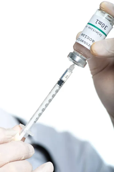 Vue recadrée de la seringue et du vaccin contre le coronavirus entre les mains d'un médecin isolé sur blanc — Photo de stock