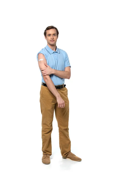Man with adhesive patch on arm looking at camera on white background — Stock Photo