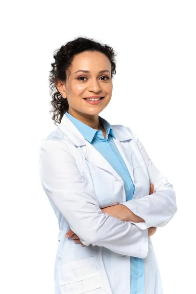 Smiling african american doctor in white coat looking at camera isolated on white — Stock Photo
