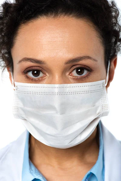 Retrato de médico afroamericano en máscara médica aislado en blanco - foto de stock