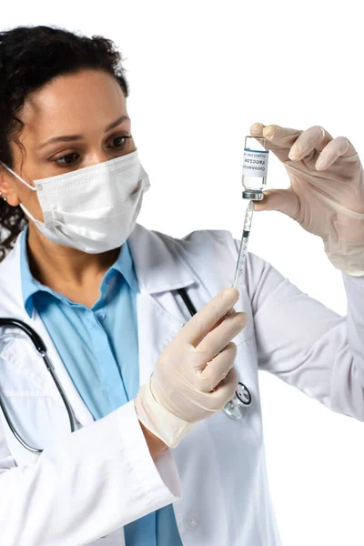 Coronavirus vaccine and syringe in hands of blurred african american doctor isolated on white — Stock Photo