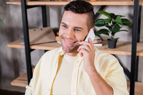 Hombre alegre hablando en el teléfono móvil en casa - foto de stock