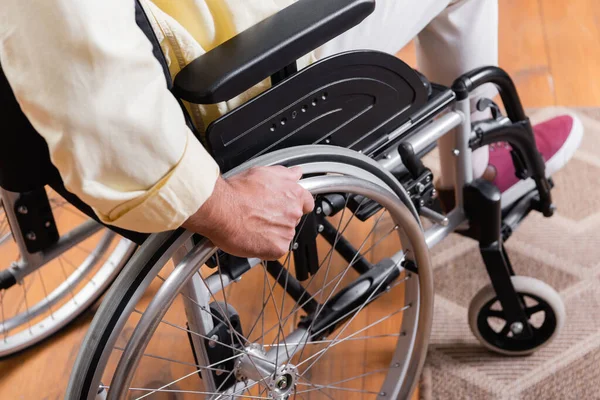 Vue partielle du jeune homme en fauteuil roulant à la maison — Photo de stock