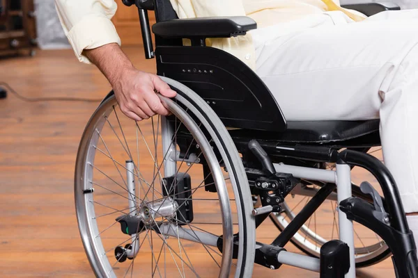 Vista recortada del hombre discapacitado sentado en silla de ruedas - foto de stock