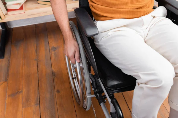 Vista cortada do homem com deficiência sentado em cadeira de rodas em casa — Stock Photo