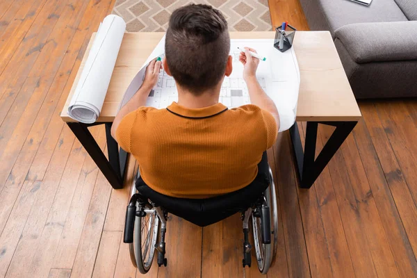 Vue aérienne de l'ingénieur handicapé travaillant près du plan à la maison — Photo de stock