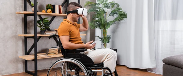 Вид збоку веселий, інвалідний чоловік грає в гарнітуру vr вдома, банер — стокове фото