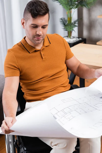 Behinderter Ingenieur schaut sich Bauplan bei der Arbeit zu Hause an — Stockfoto