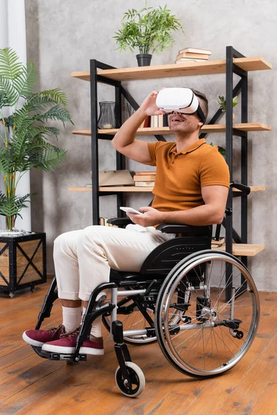 Joyful disabled man adjusting vr headset while gaming at home — Stock Photo