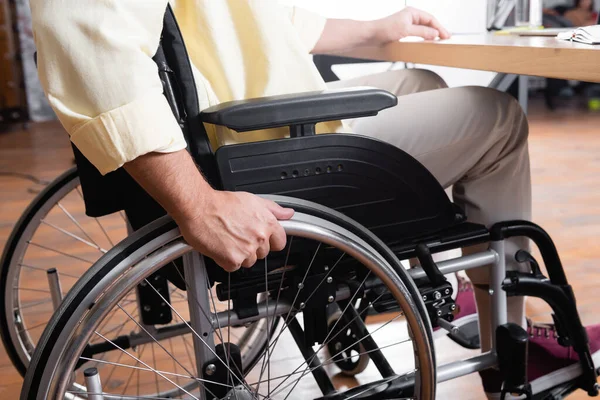 Visão parcial do jovem sentado em cadeira de rodas em casa — Stock Photo