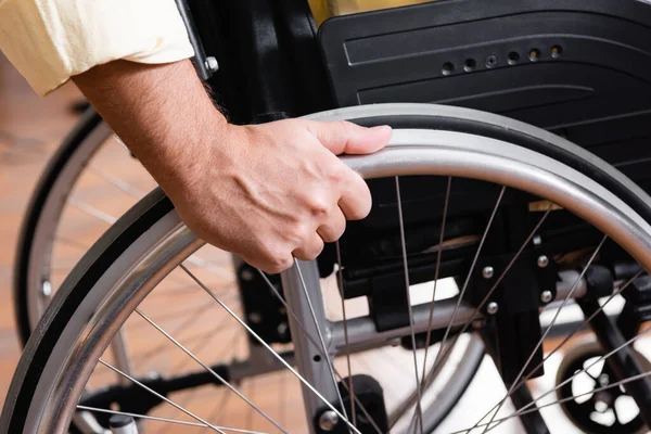 Vista recortada del hombre discapacitado en silla de ruedas en casa - foto de stock