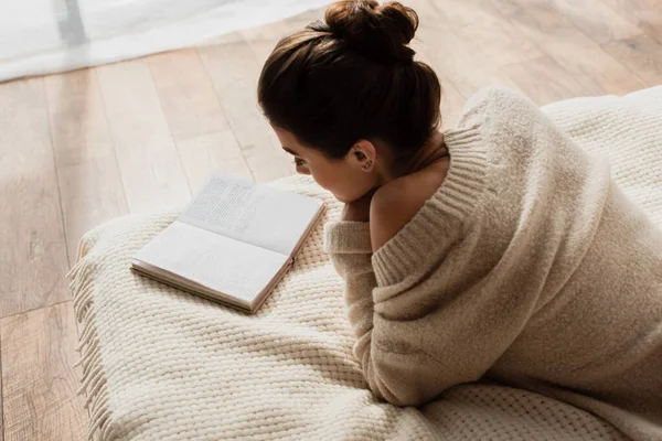 Молода жінка читає роман під час відпочинку на ліжку вдома — стокове фото
