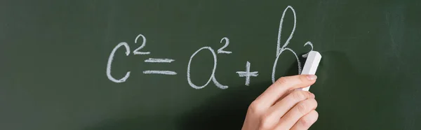 Cropped view of teacher writing equation on chalkboard, banner — Stock Photo